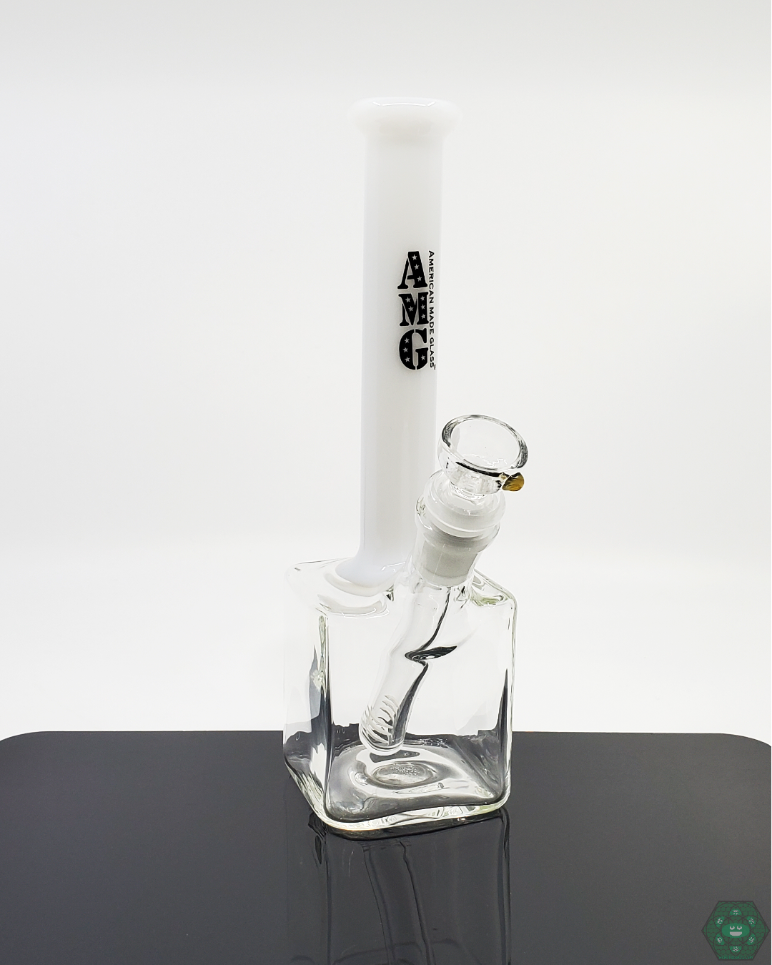 9 Inch Cube Base Beaker Bong by AMG Glass. This compact beaker features a 7-hole perc for smooth filtration, a 14mm joint, and a removable downstem for easy maintenance. Available in multiple color accents.