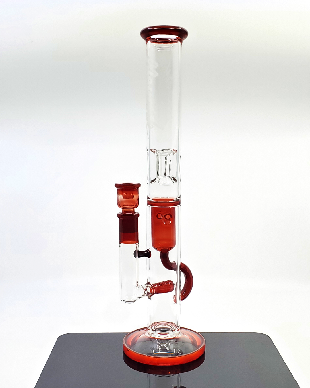 Side view of the Monark Glass 50mm Stemline Recycler, showcasing its striking red color and functional recycler design for an enhanced smoking experience.